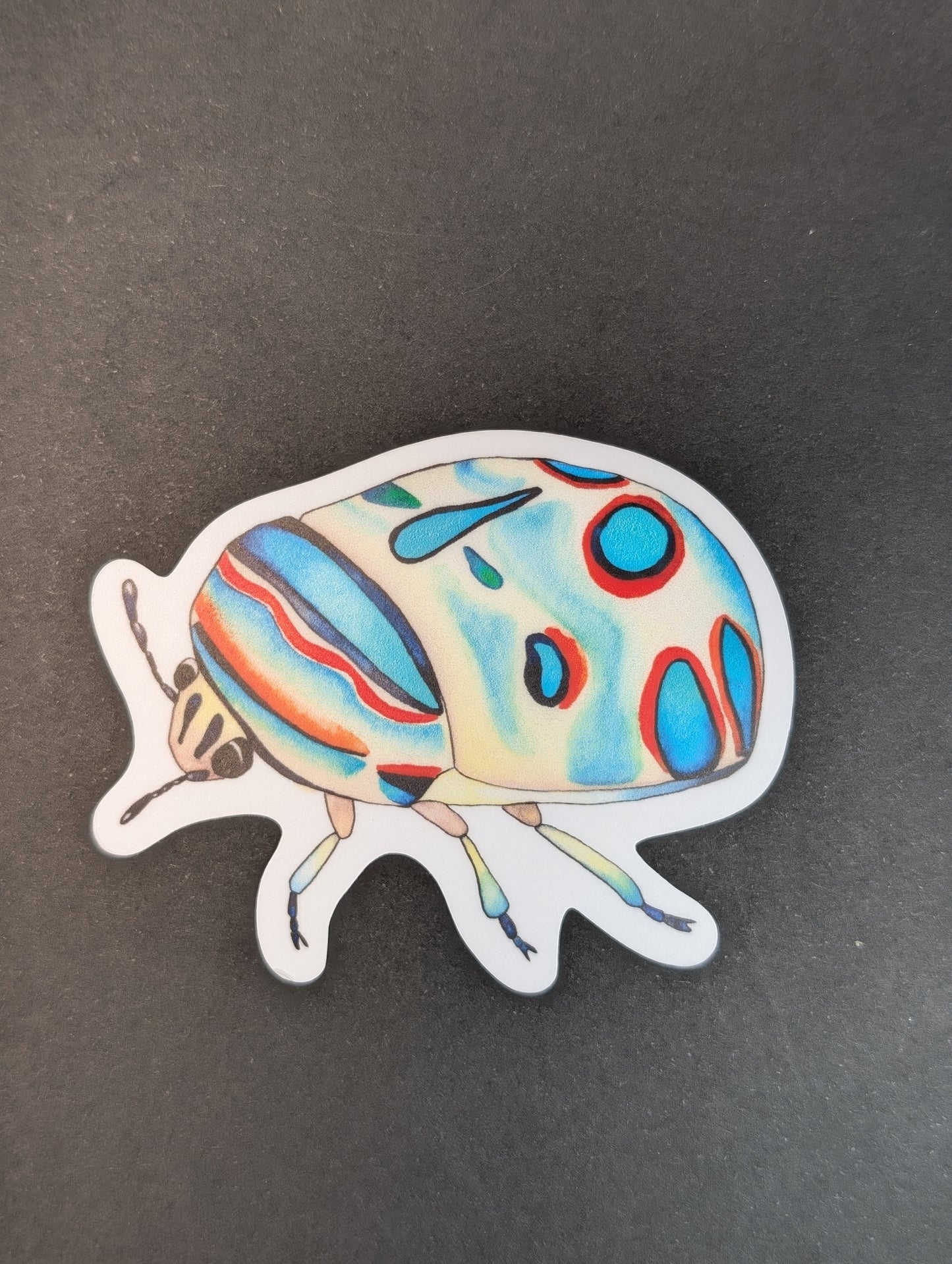 Colorful beetle-shaped sticker on a dark background