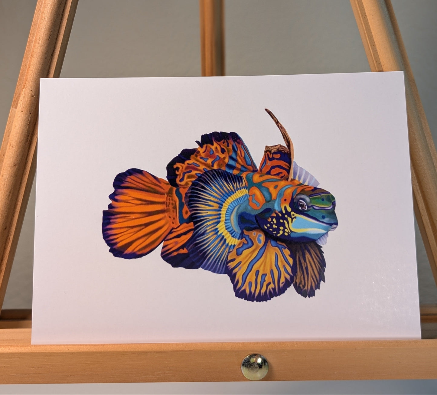 Print of a mandarin fish with blue, orange, and yellow patterns