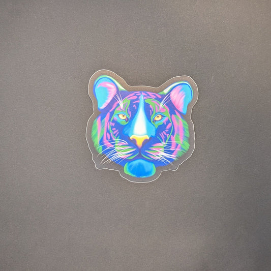 Picture of a sticker of a tiger face in neon colors on a black background.