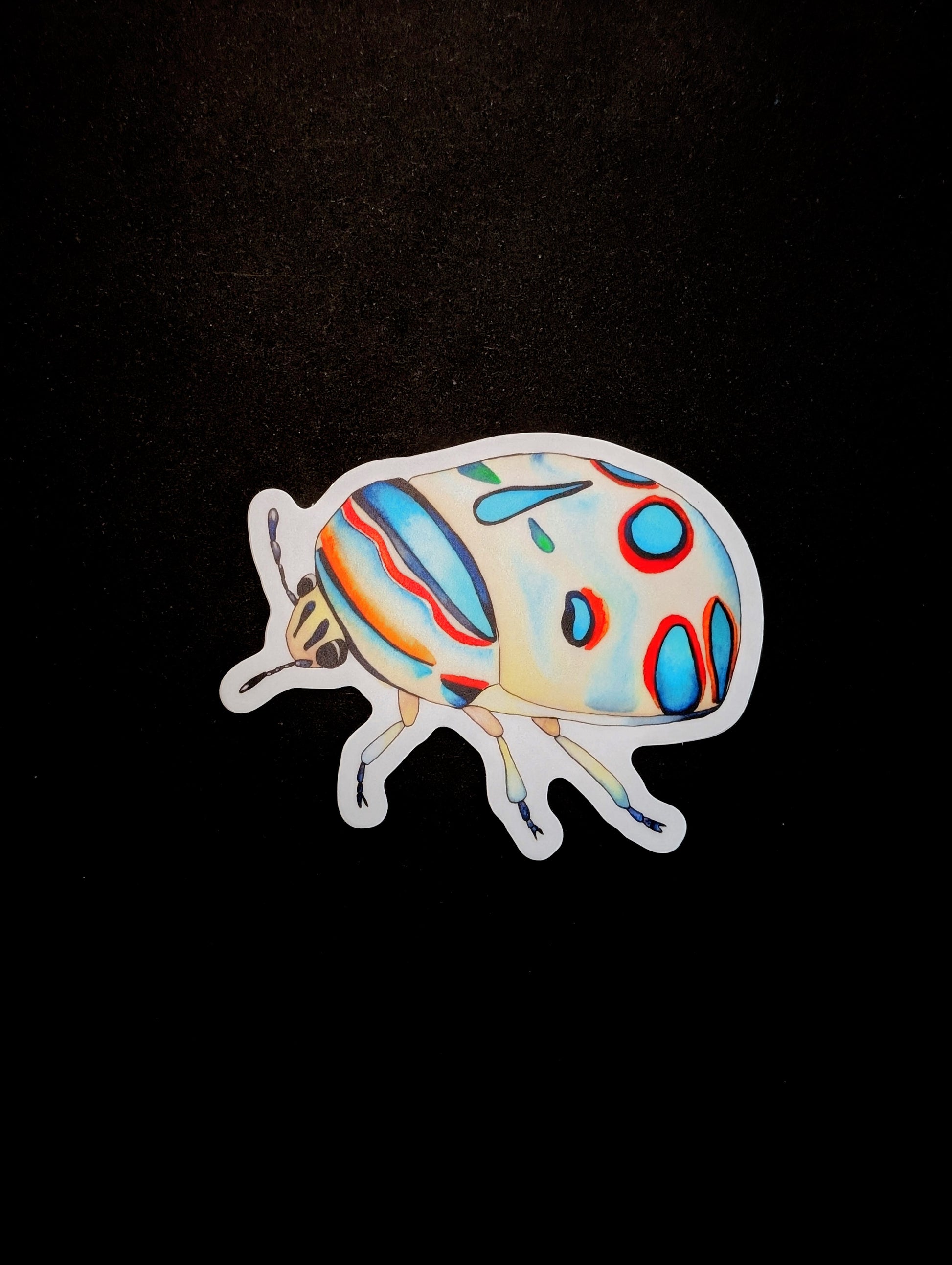 Vinyl sticker of a Picasso bug created with watercolor. Sticker is on a black backgorund.