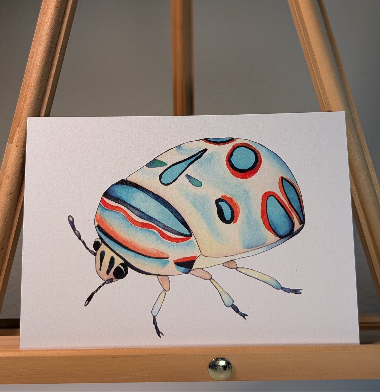 Print of colorful beetle with blue and red on its shell